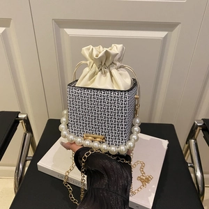 Chic hand-held bucket bag with geometric patterns, pearl handle and gold chain strap
