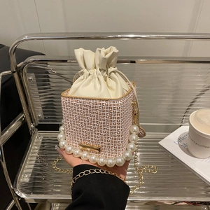 Chic cream bucket bag with vintage monogram, pearl handle and gold chain strap