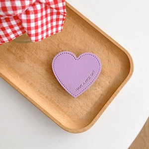 Detail of purple heart leather grip with Have A Nice Day text and fine stitching