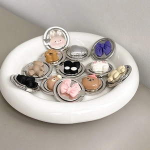 Detailed view of assorted metal phone ring holders with cute resin animal and bow designs