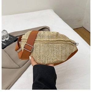 Detail of beige straw fanny pack featuring herringbone weave and adjustable brown strap