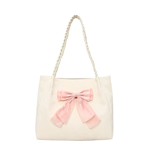 Chic cream tote bag featuring a large pink bow detail and woven rope handles
