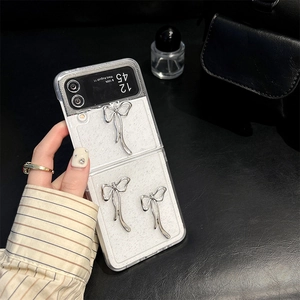 Close-up of glitter transparent phone case with silver 3D bow charms for Samsung Z Flip