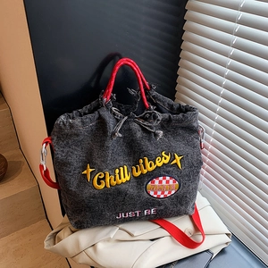 Gray washed denim bucket bag with Chill vibes embroidery and red drawstring straps