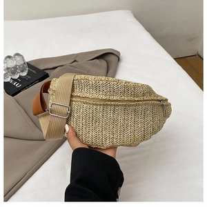 Detail of woven straw sling bag with canvas strap and metal buckle on lifestyle setup