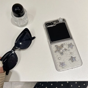 Detail of Z Flip case with silver glitter, faux pearls and star charms in a lifestyle setup