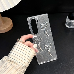 Detail showing transparent glitter phone case with three silver 3D bowknot accessories