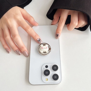Close-up of a cute white bear phone ring holder attached to a white smartphone back