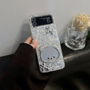 Detail of glitter Z Flip case featuring a rhinestone bear mirror and balloon dog charm