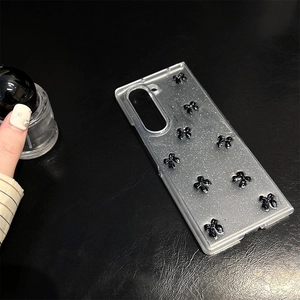 Glitter transparent case for Samsung Z Flip 6 with 3D black bows on leather surface