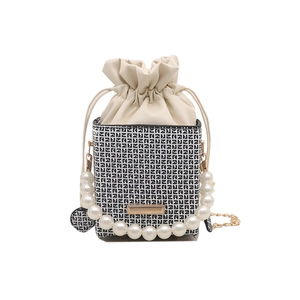 Elegant pearl handle bucket bag with black and white geometric pattern and gold chain strap