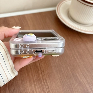 Detail view of transparent folding phone case with 3D resin bear and flower charms