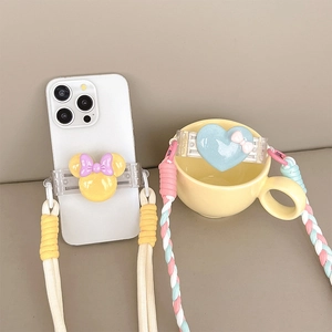 Detailed view of phone back clips with cartoon charms and colorful woven crossbody straps