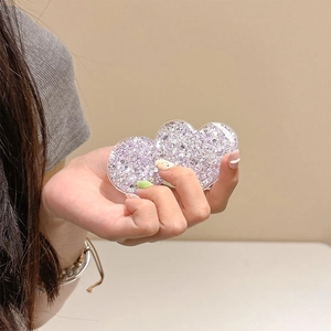 Close-up of heart-shaped phone grip with purple glitter and silver sequins inside