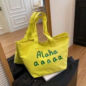 Large yellow canvas tote bag with green letter print for daily commute and shopping