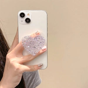 Close-up of heart-shaped phone grip with purple glitter on a white smartphone