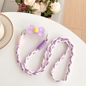 Detailed view of a colorful braided phone lanyard with a purple flower clip on a table