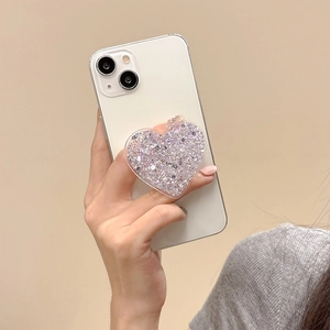 Detail showing heart-shaped phone grip with purple and silver glitter held on a white phone