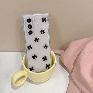 Detail of glitter phone case with black 3D bows for Samsung Z Flip series in a cozy cup