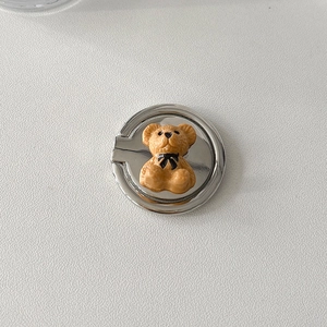 Close-up of a silver metal phone ring holder with a 3D brown teddy bear and bow