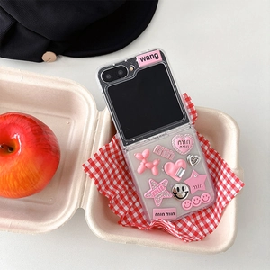 Detail of pink resin charms with dog and heart motifs on a clear folding phone case