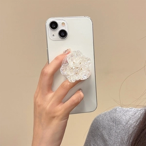 Support de téléphone extensible en forme de fleur nacrée sur un smartphone blanc