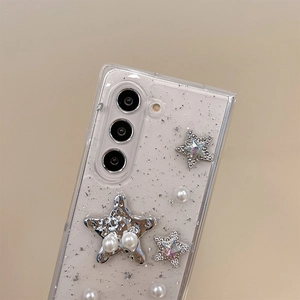 Macro detail of clear phone case with silver glitter, stars and elegant pearls