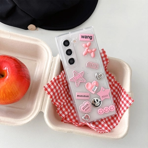 Detailed view of pink 3D balloon dog and heart charms on a clear Y2K phone case
