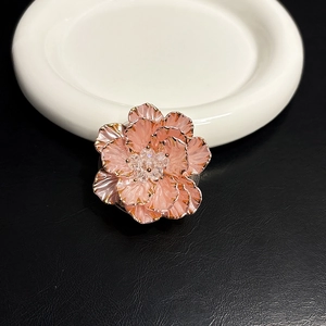 Vue détaillée d'un support de téléphone fleur rose élégant avec des bords dorés.