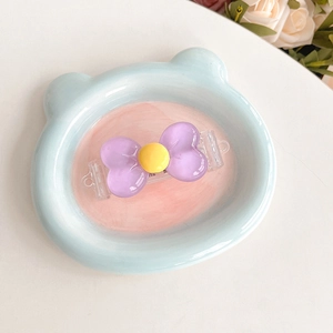 Purple bow phone back clip with yellow center on a cute bear-shaped tray accessory