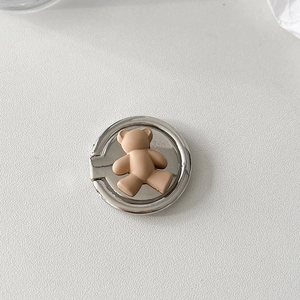 Macro shot of cute brown bear phone ring holder with a polished silver metal base