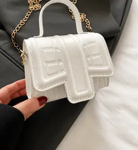 Detailed view of a trendy white stone texture mini square bag with gold chain strap