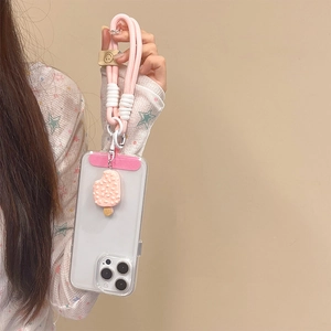 Detail view of pink braided phone strap with a cute 3D cream popsicle silicone pendant