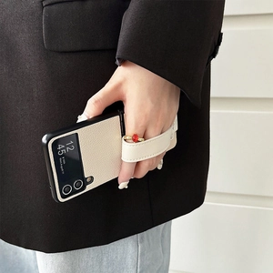 Macro detail of beige lychee leather case for Galaxy Z Flip with integrated hand strap