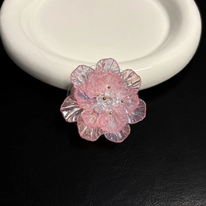 Vue détaillée d'un support de téléphone en forme de fleur en résine rose sur cuir noir