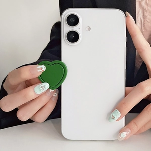 Detail view of a vibrant green heart-shaped adhesive phone grip on a white smartphone