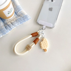 Detail of woven phone lanyard with cute cream ice cream pendant and leather tag