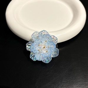 Gros plan d'un support de téléphone en forme de fleur bleue irisée sur une assiette