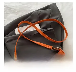 Detail of orange faux crocodile skin texture with gold rivets on an elegant handbag