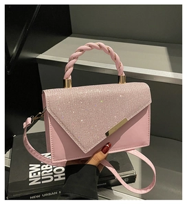 Détail du sac en cuir rose avec rabat à strass brillants et poignée tressée élégante