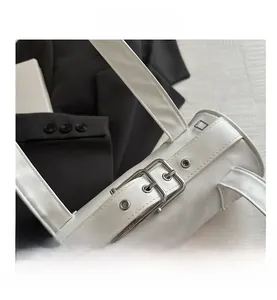 Detail of white cylindrical shoulder bag featuring smooth PU leather and silver buckle