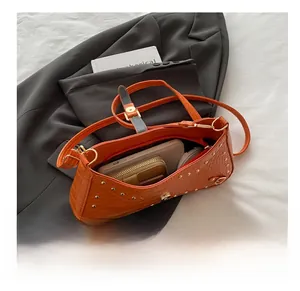 Detail view of orange crocodile-pattern bag interior showing phone and wallet storage