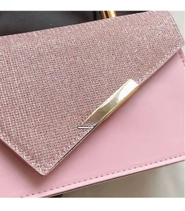 Détail du sac à main en cuir rose avec tissu pailleté et bordure dorée chic