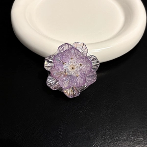 Vue détaillée des pétales irisés d'un support de téléphone en forme de fleur violette