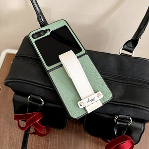 Detail of green litchi leather case with white finger strap for foldable smartphone