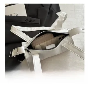 Internal view of white cylinder shoulder bag showing space for phone, wallet and airpods