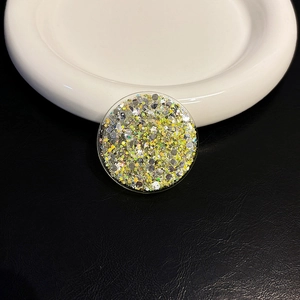 Macro view of round phone socket grip featuring colorful glitter and silver sequins