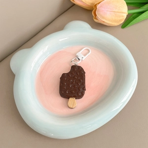 Detail of a chocolate ice cream charm with texture on a blue bear-shaped ceramic plate