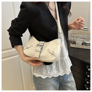 Detail of off-white crocodile embossed baguette bag with silver buckle and rivets
