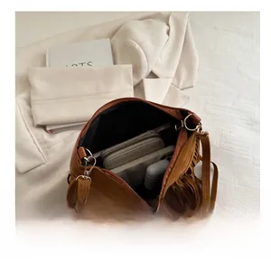 Interior view of brown suede fringe bag showing storage space for phone and wallet